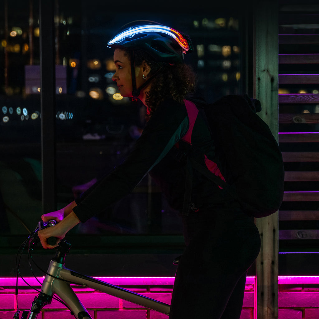 Female on cycle with NightBlazr attached to helmet at night